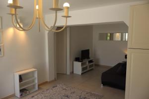 a living room with a black couch and a television at Fig Tree in Povlja