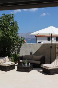 a patio with two couches and an umbrella at Fig Tree in Povlja