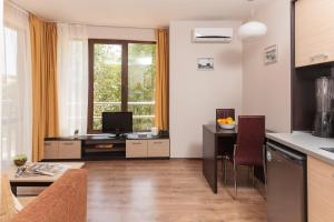 a living room with a kitchen and a desk with a television at All-inclusive Holiday Apartments in Tarsis Hotel & Aquapark in Sunny Beach