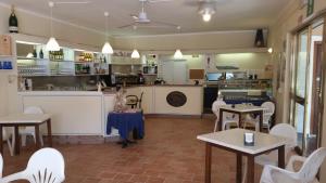 ein Restaurant mit Tischen und Stühlen und eine Küche in der Unterkunft Residence Napoleon by HelloElba in Procchio
