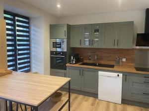 a kitchen with green cabinets and a counter top at La Maison Du Pavé in Villedieu-les-Poêles
