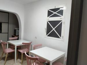 two tables and chairs in a room with a window at Guesthouse Los Geranios in Mocanal +17 photos