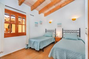 Un dormitorio con dos camas y una ventana en Tintorer, en Puerto Pollensa 14 fotos más