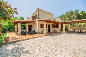 una casa con un patio de piedra frente a ella en Tintorer, en Puerto Pollensa