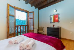 a bedroom with a bed with three towels on it at Casa Soles Naturaleza y Tranquilidad en los Picos de Europa in Congarna