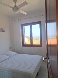 a white bedroom with a bed and a window at 6CHK4 Villa 6 personnes dans résidence in Collioure