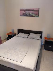 a bedroom with a large bed with white sheets at Home Sweet Home Skala Fourkas in Skála Foúrkas