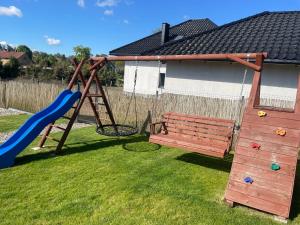 a playground with a bench and a slide at Urocze domki #1, Domek Sitno 69F KASZUBY in Sitno +11 photos