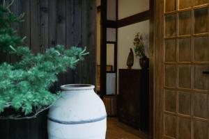 a large white vase sitting on the floor next to a door at LA TERRA narai in Shiojiri