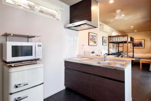 a kitchen with a sink and a microwave at Surf and Sand in Onjuku