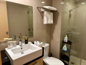 um banheiro com pia, vaso sanitário e chuveiro em Amazing Sunrise Venice Grand Canal Balcony, Xbox Series X console with Game Pass Ultimate, FREE coffee, Pool, Gym & Sauna, 5 mins to BGC em Manilla mais 48 fotografias