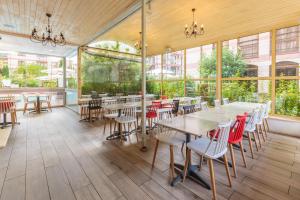 a restaurant with tables and chairs and windows at All-inclusive Holiday Apartments in Tarsis Hotel & Aquapark in Sunny Beach
