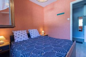 a bedroom with a bed with blue and white pillows at Vacances cures luchon in Luchon