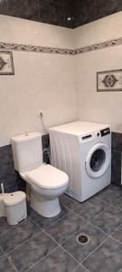 Un baño con inodoro y lavadora. en Demetra's House, en Volos