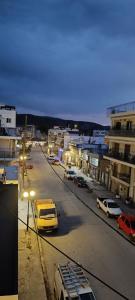 una ciudad con coches aparcados en un estacionamiento por la noche en Demetra's House, en Volos