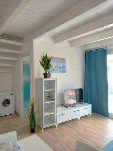 ein Wohnzimmer mit einem weißen Schrank und einem TV in der Unterkunft Affittimoderni Isola Rossa Borgo - Ulivi 9 in Isola Rossa