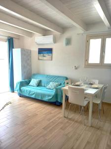 ein Wohnzimmer mit einem blauen Sofa und einem Tisch in der Unterkunft Affittimoderni Isola Rossa Borgo - Ulivi 9 in Isola Rossa