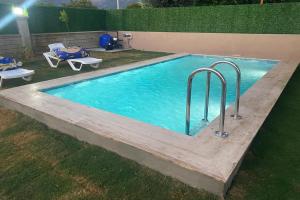 een zwembad met twee stoelen in een tuin bij Likya Karya Villaları in Koycegiz