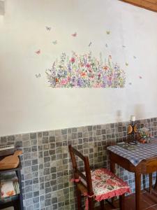 a wall with a painting of flowers and butterflies at Borgo Il Monzone in Castel dʼAiano +27 photos