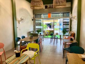 a restaurant with tables and chairs and windows at 326 Podtel at The Breakie Bar in Bangkok