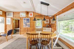 a kitchen and dining room with a table and chairs at Hirsimökki kansallispuistossa in Espoo