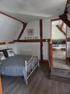 a bedroom with a bed with a sign on the wall at Les Petits Champs in Buais