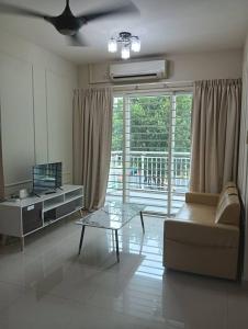 Una sala de estar con un sofá y una mesa de cristal. en IJM Sri Utama Condo, en Sandakan