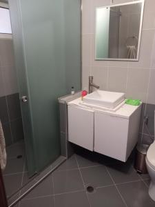 Un baño con lavabo blanco y ducha. en Eleni's, en Sarandë