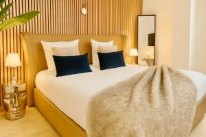 a bedroom with a large white bed with blue pillows at Apartment Duplex with Sauna City- Center Cathedrale in Strasbourg