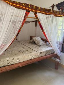 a bed in a room with curtains on it at JozaniBiospherevillage in Jozani