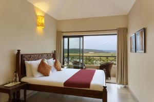 a hotel room with a bed and a balcony at 5 Tropical Woods 4 BR VillaGoa Pool Cook in Bardez