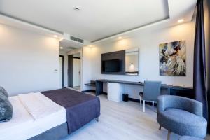 a bedroom with a bed and a desk and a chair at Wind of Çeşme in Çeşme