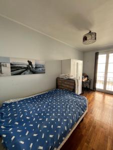 Un dormitorio con una cama con un edredón azul. en Appartement Le Havre, en Le Havre