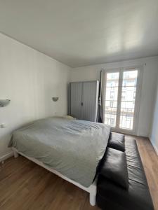 Un dormitorio blanco con una cama y un sofá. en Appartement Le Havre, en Le Havre 2 fotos más