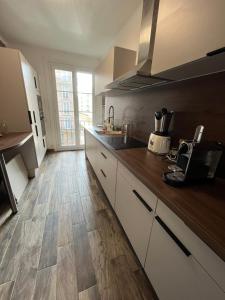 cocina con armarios blancos y suelo de madera en Appartement Le Havre, en Le Havre