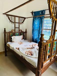a wooden bed in a room with a window at JozaniBiospherevillage in Jozani
