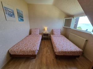 ein Zimmer mit zwei Betten und einem Fenster in der Unterkunft Évasion bretonne au bord de l'eau in Plouguerneau + 22 Fotos