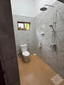 a bathroom with a white toilet and a shower at JozaniBiospherevillage in Jozani