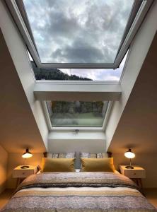 a bedroom with a large window above a bed at Stilvolles Loft mit Naturpool in Mels