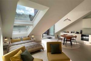 a bedroom with a bed and a table and a kitchen at Stilvolles Loft mit Naturpool in Mels