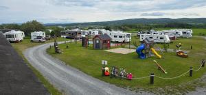 a park with a bunch of rvs and a playground at Le Pirate Motel et Camping in Cap-Chat