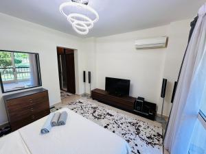 a white room with a bed and a television at Luxury Inn 3BR Amazing Garden view in Madinaty B1 in Madinaty