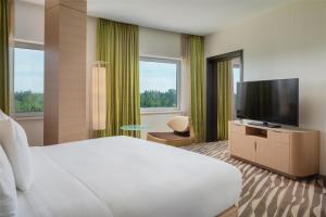 a hotel room with a bed and a flat screen tv at Hilton Frankfurt Airport in Frankfurt/Main