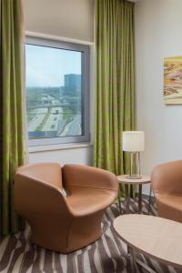 a hotel room with a chair and a window at Hilton Frankfurt Airport in Frankfurt/Main
