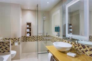 a bathroom with a sink and a glass shower at Hilton Frankfurt Airport in Frankfurt/Main