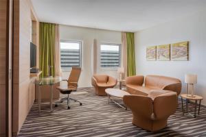 a waiting room with chairs and a table at Hilton Frankfurt Airport in Frankfurt/Main