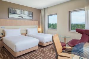a hotel room with two beds and a table at Hilton Frankfurt Airport in Frankfurt/Main