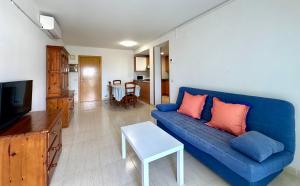 a living room with a blue couch and a table at Home Vila-seca Town in Vilaseca de Solcina