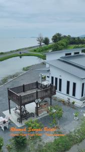 a bench sitting in front of a white building at Rhumah Sungai Belati in Simpang Empat