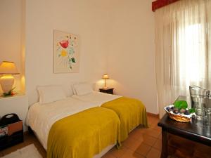 a bedroom with a bed with a yellow blanket at Betica Hotel Rural in Pias